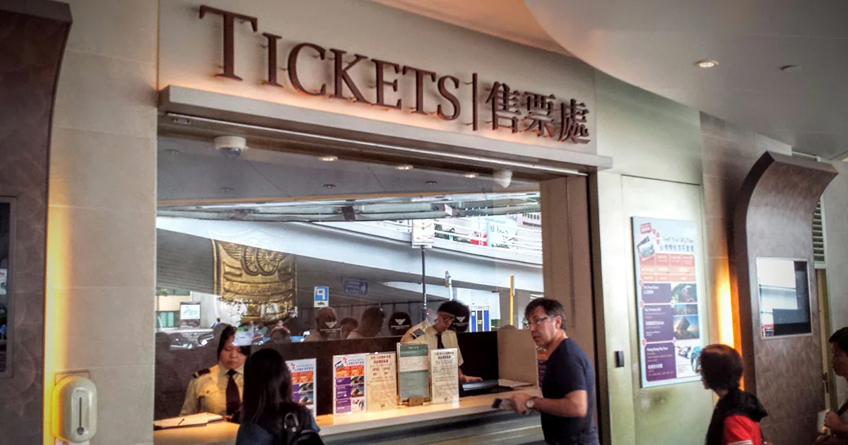 Peak Tram ticket counter at Garden Road, Hong Kong, with bilingual signage and staff serving visitors