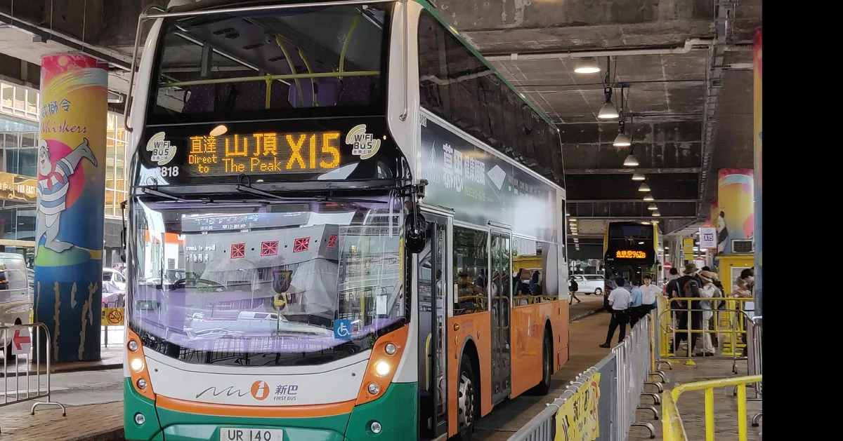 Double-decker bus at The Peak bus terminus in Hong Kong with passengers nearby
